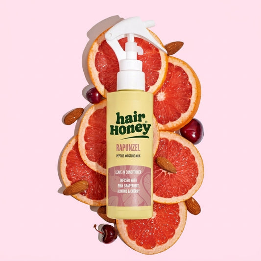 Close-up of Hair Syrup Rapunzel Leave-In Conditioner Spray 100ml with a floral background.