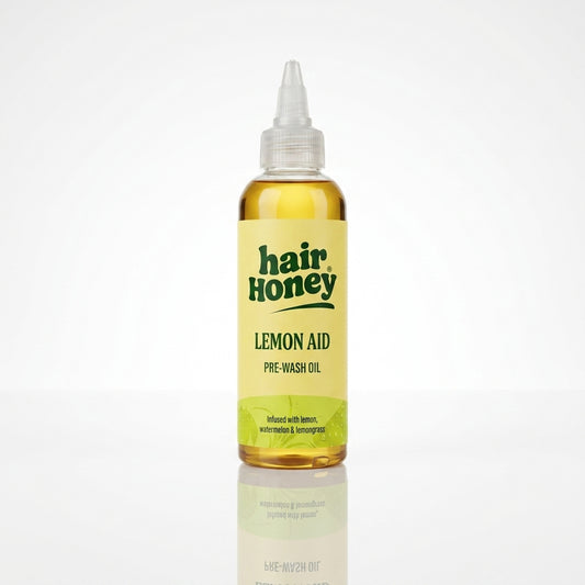 Lemon Aid Pre-Wash Treatment for Oily Hair in a vibrant yellow bottle on a wooden surface.