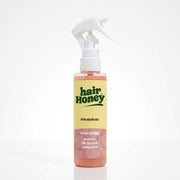 Hair Syrup Rapunzel Leave-In Conditioner Spray 100ml bottle on a wooden surface.