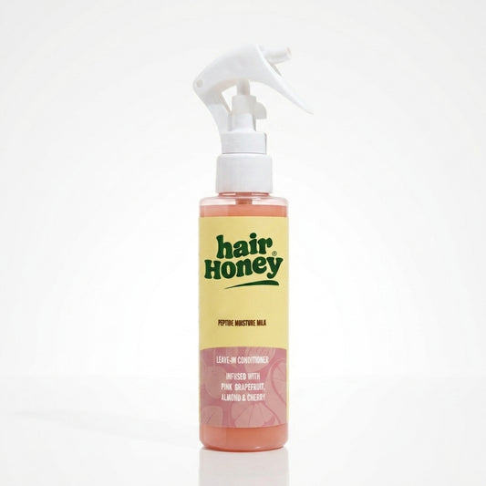 Hair Syrup Rapunzel Leave-In Conditioner Spray 100ml bottle on a wooden surface.